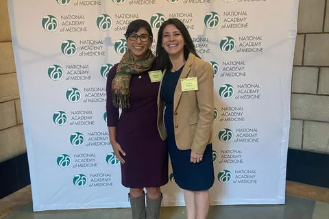 Drs. Cecilia Canales and Alejandra Casillas standing in front of a conference backdrop.