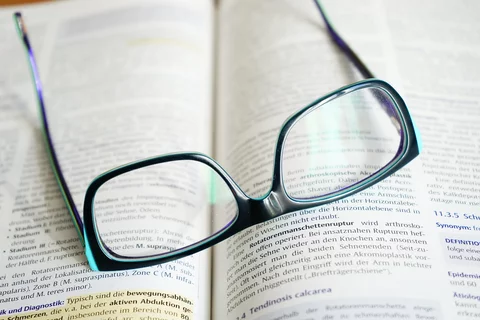 Reading glasses on top of an open book.
