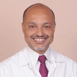Headshot of Dr. Kenrik Duru in medical coat and red tie